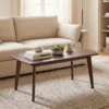 Angled shot of the walnut wood-grain coffee table with tapered legs on a rug