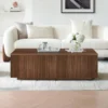 Fluted wood coffee table styled with books and a tray in a warm living room