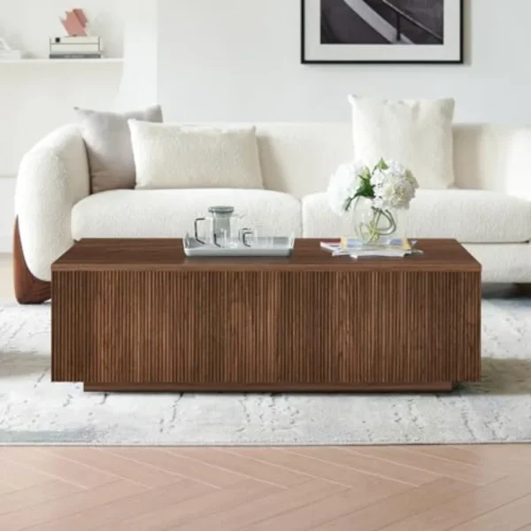 Fluted wood coffee table styled with books and a tray in a warm living room