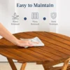 Close-up of the sealed light teak finish and open-slat tabletop of the wood outdoor table and chairs