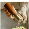 Cylindrical ceramic seasoning grinder and jar set with acacia wood accents, Japanese-style design for black peppercorns and kitchen use.